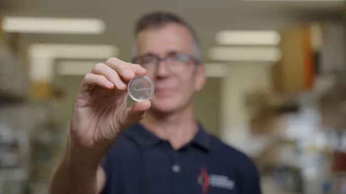 Griffith University's Professor James St John holding a nerve bridge