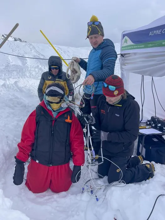 Participant ready for burial. Giacomo Strapazzon (kneeling) and Frederik Eisendle (blue jacket) both are researchers and doctors who led the study.