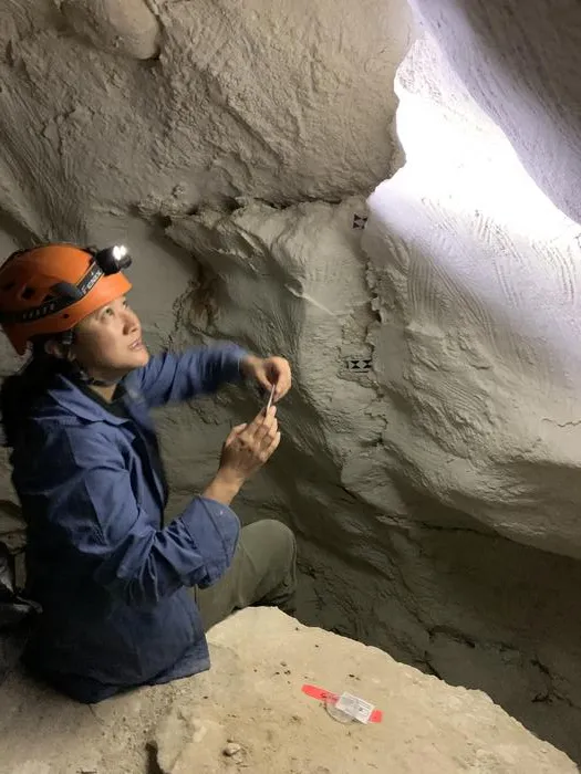 Dr Andrea Jalandoni studies finger flutings at a cave site in Australia