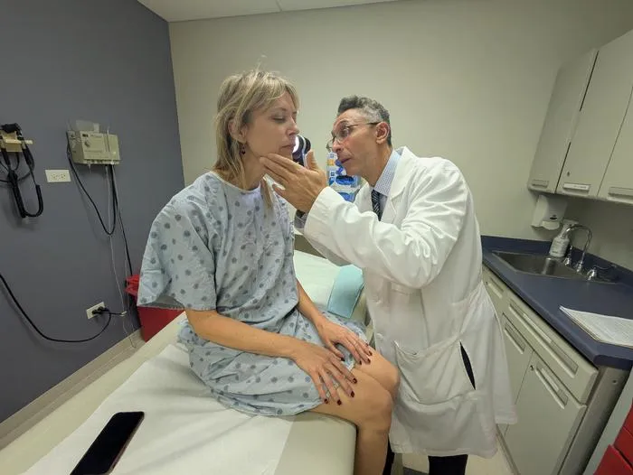 Dr. Pedram Gerami examines the skin of patient and melanoma survivor Heidi Tarr