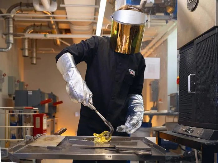 Research molds a piece of glass after removing it from a forge