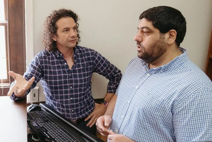 Two men sitting in an office talking with each other