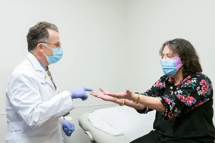 Dr. Igor Koralnik meets with a patient in the Comprehensive COVID-19 Center at Northwestern Medicine