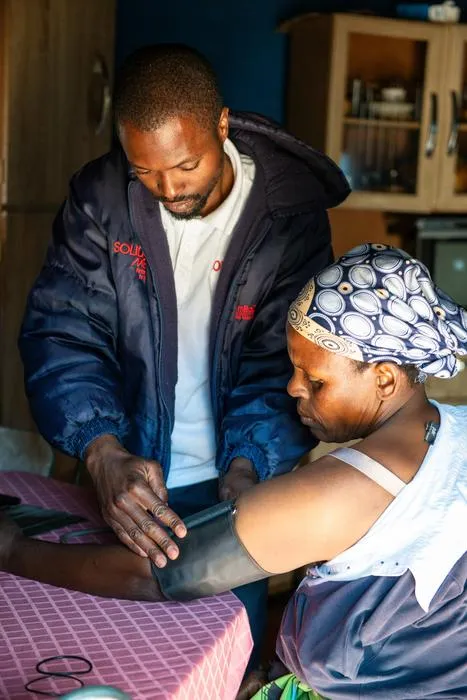 Lay health worker measure blood pressure of patient