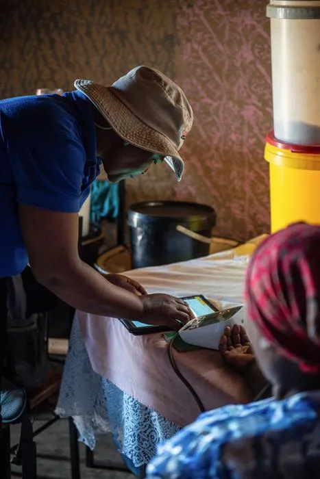 Lay health worker with hypertension patient in her home