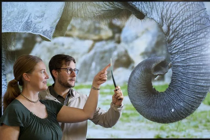 Researchers holding 3D-printed whisker