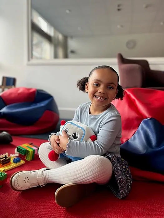 Mya, age 3, with the Gabbo toy used in the study, during an observation at the Faculty of Education, University of Cambridge.