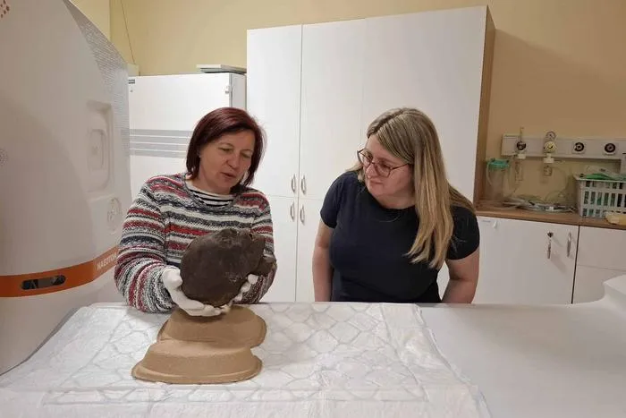 Krisztina Scheffer (MNMKK Semmelweis Museum of Medical History) and Dr. Ibolyka Dudás (Medical Imaging Center (OKK)) holding the mummified head of an Egyptian woman