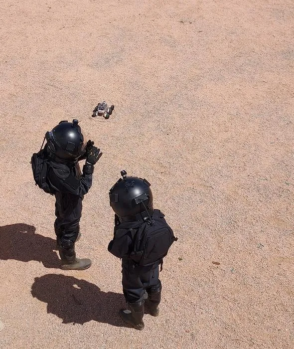 Two students carry out a “space walk” wearing protective suits