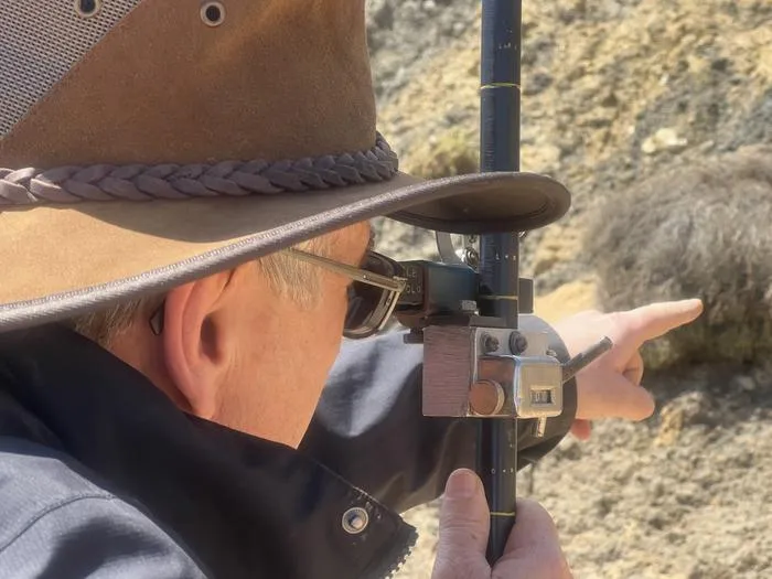 Associate Professor Stephen Gallagher uses a Jacob's staff to measure the rock layers