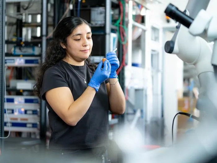 Valeska Zambra inspects a sample of UTe2