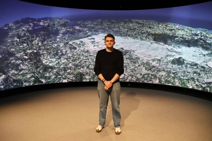 Dr Anthony Clarke in front of a 3D image of the Batavia wreck site. Credit - Curtin University