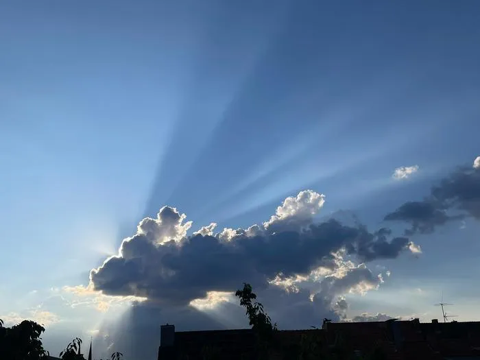 Sunbeams radiating from behind cloud formations