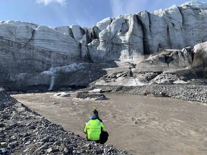 Taking water samples from a glacial river on Svalbard