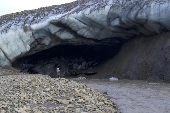 River flowing out of the bottom of a melting Svalbard glacier