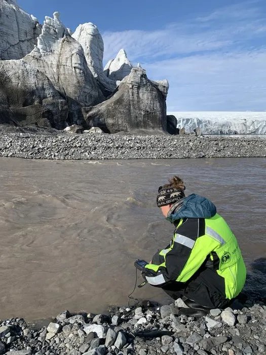 Taking hydrochemical measurements of a glacial river on Svalbard