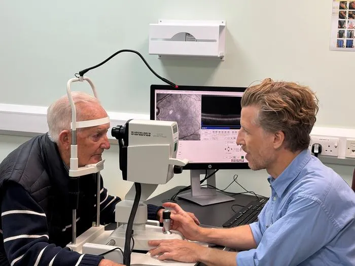 Dr Josef Huemer looking at John Brewer's eyes