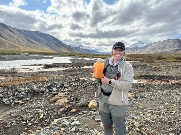 Taylor Evinger with orange river water in Alaska
