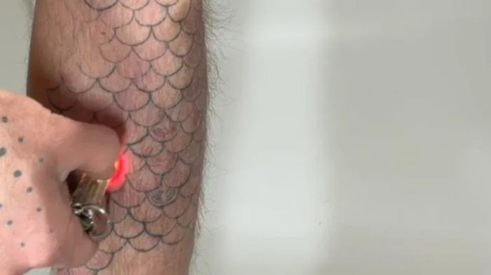 Scales tattoo under light