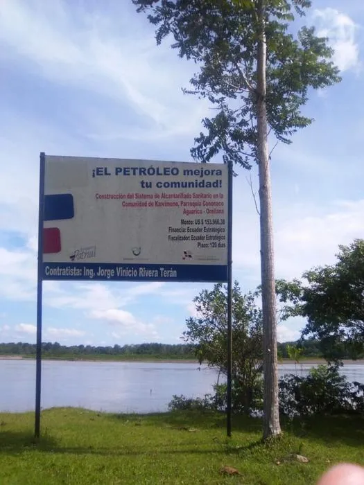 A sign by state oil company Petroamazonas that says “Oil extraction improves your community”