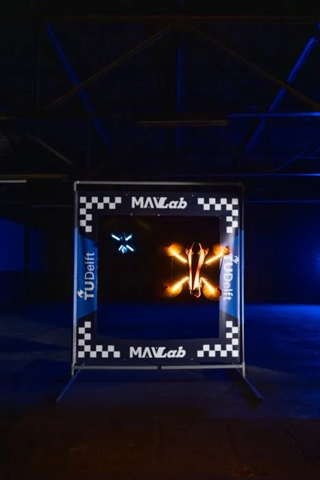An autonomous racing drone flies through a gate during trials